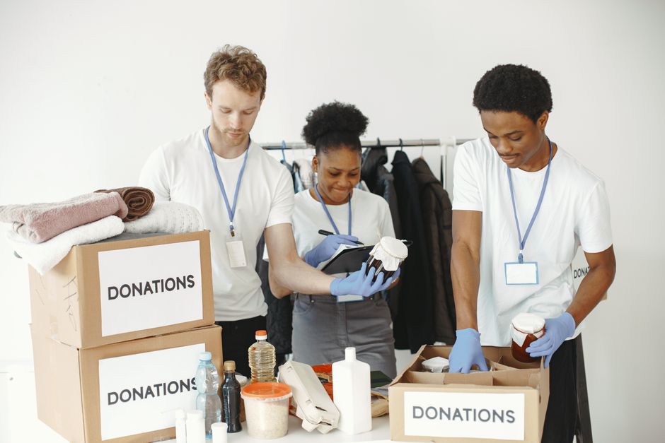 Volunteers sorting and packing food boxes in a warehouse