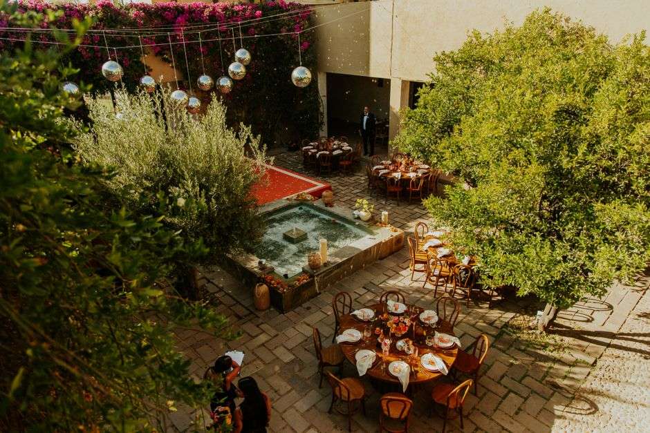 Wedding guests gathered in a courtyard with string lights at dusk