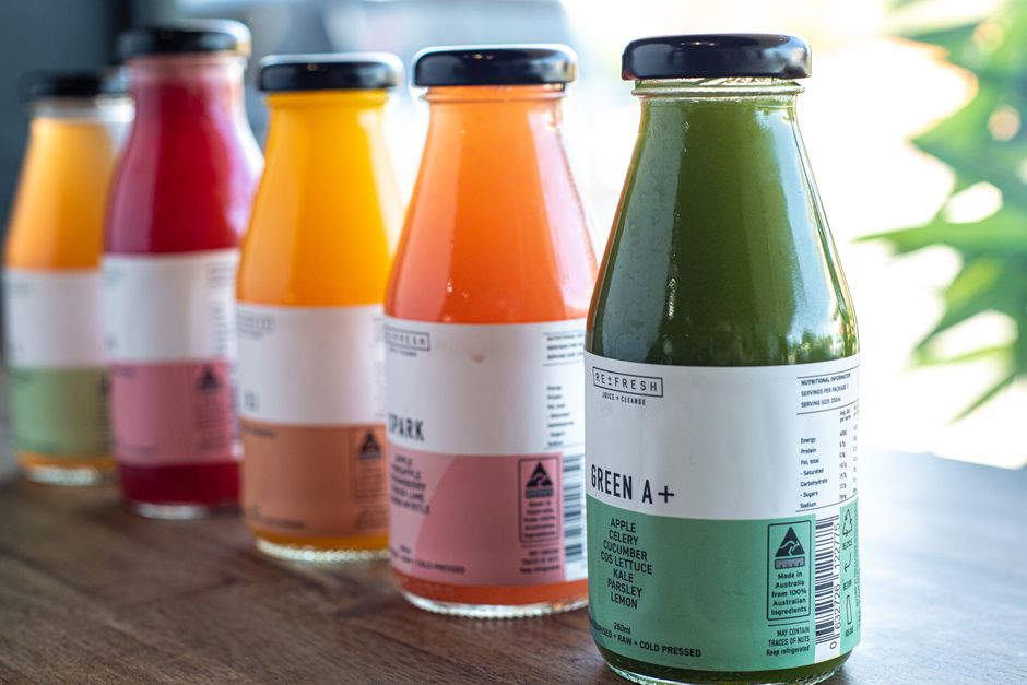 Glass bottles of fresh cold-pressed vegetable and fruit juice