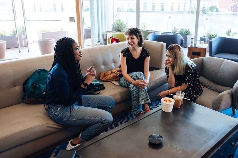 Friends talking and laughing around a table at a club gathering