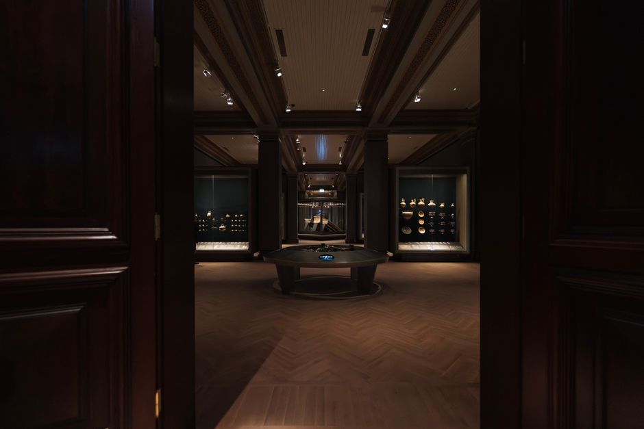 A museum exhibit hall with artifacts in glass cases and interpretive panels