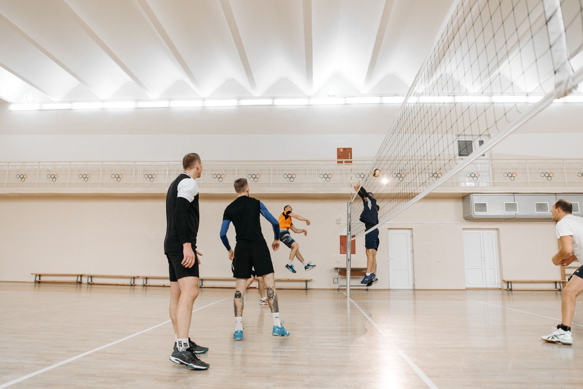 Volleyball players competing at the net during an indoor match