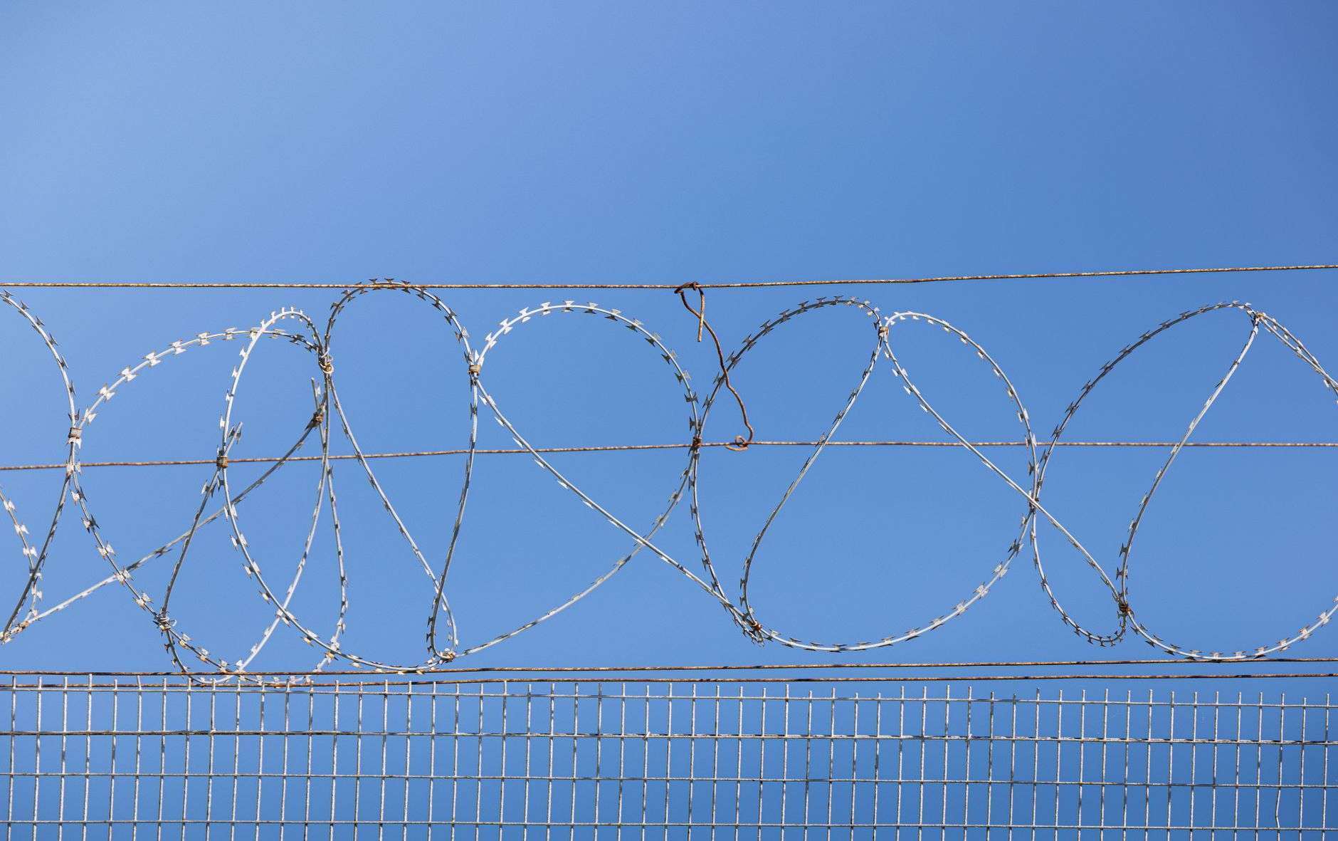Razor wire atop a chain-link perimeter fence at a correctional facility