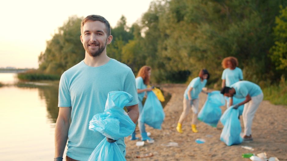 Volunteers carrying bags during a beach cleanup on the Alabama Gulf Coast