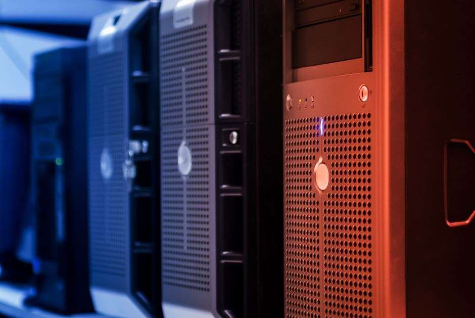 Long rows of server racks lit in blue inside a large data center hall