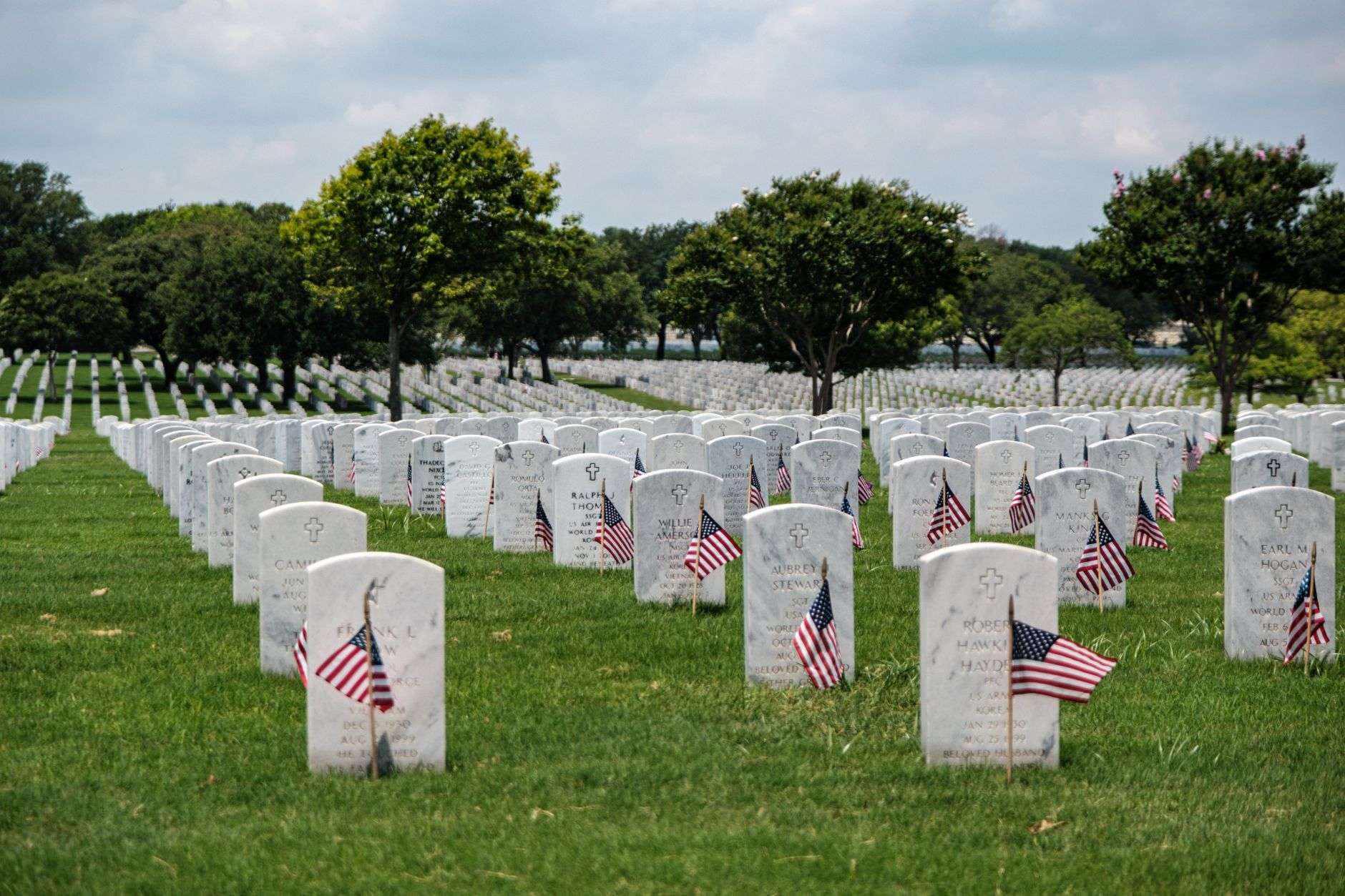 Aligned rows of white headstones at a veterans memorial cemetery
