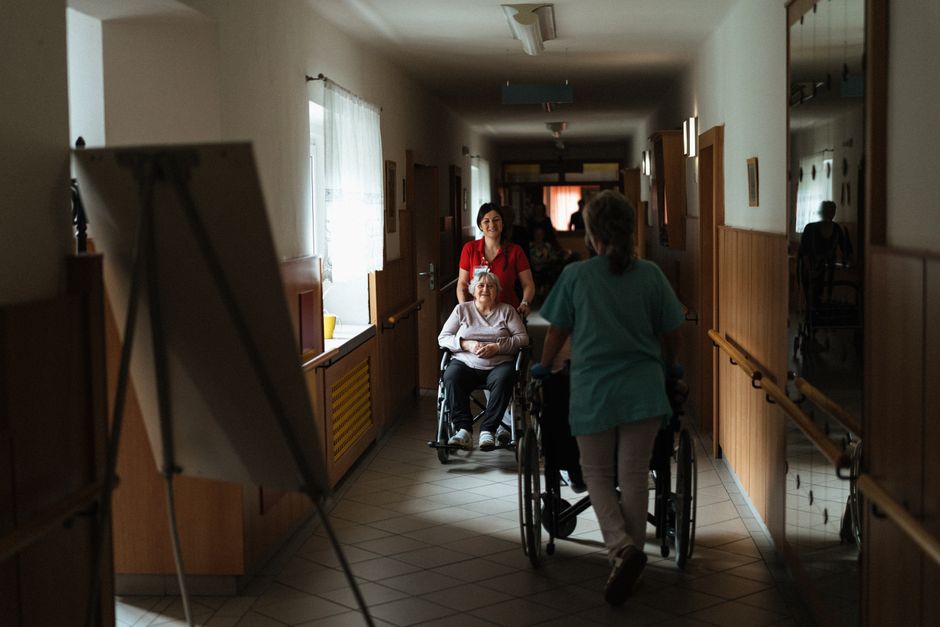 A caregiver helping a resident in a group home living room