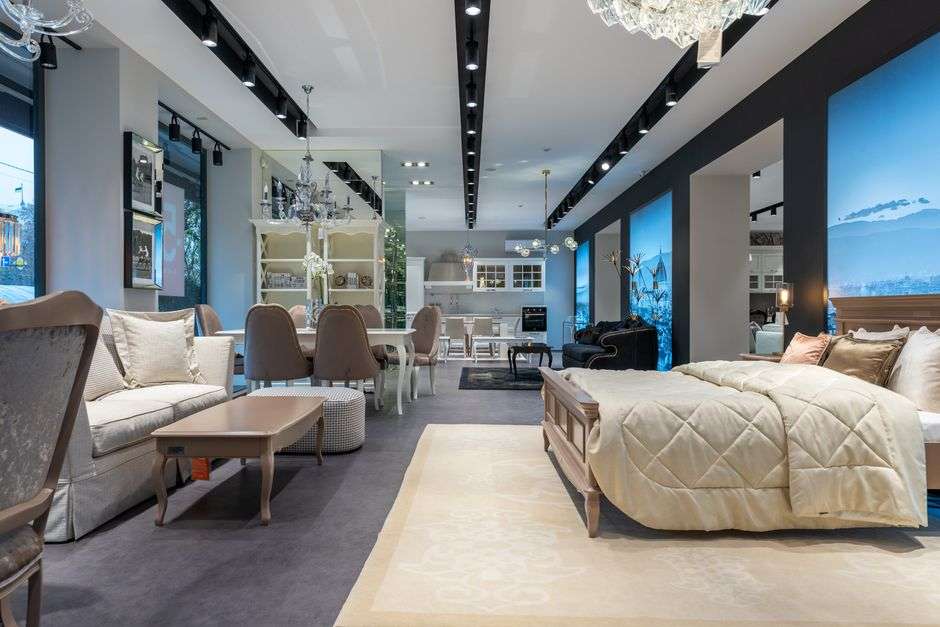 An elegant furniture showroom displaying antiques, lighting and upholstered pieces