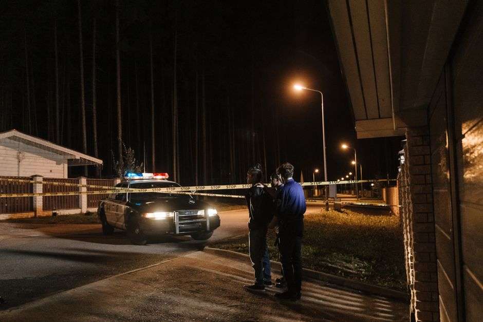 Yellow police tape stretched across a commercial parking lot