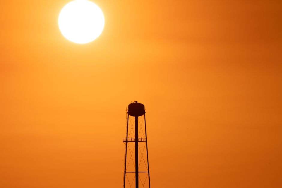 The summer sun blazing in a hazy sky over a hot Southern landscape