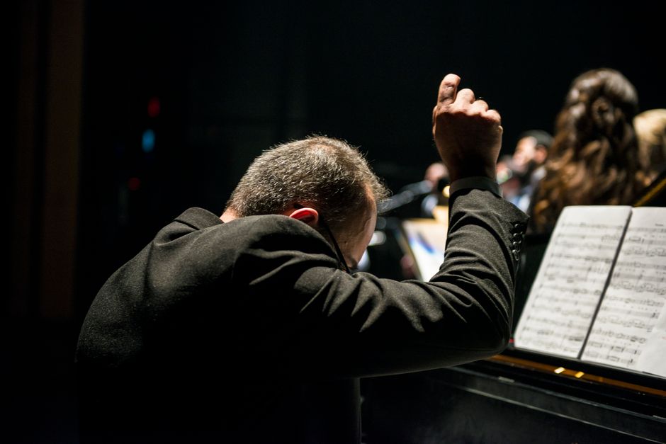 An orchestra performing on stage in a historic theater