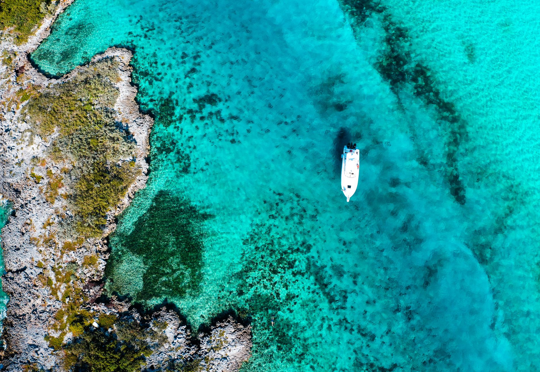 Boats moored in a calm turquoise harbor on a tropical island
