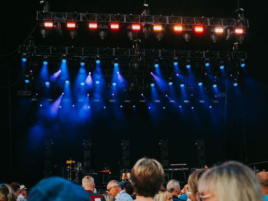 Musicians performing live on a stage lit by concert lights