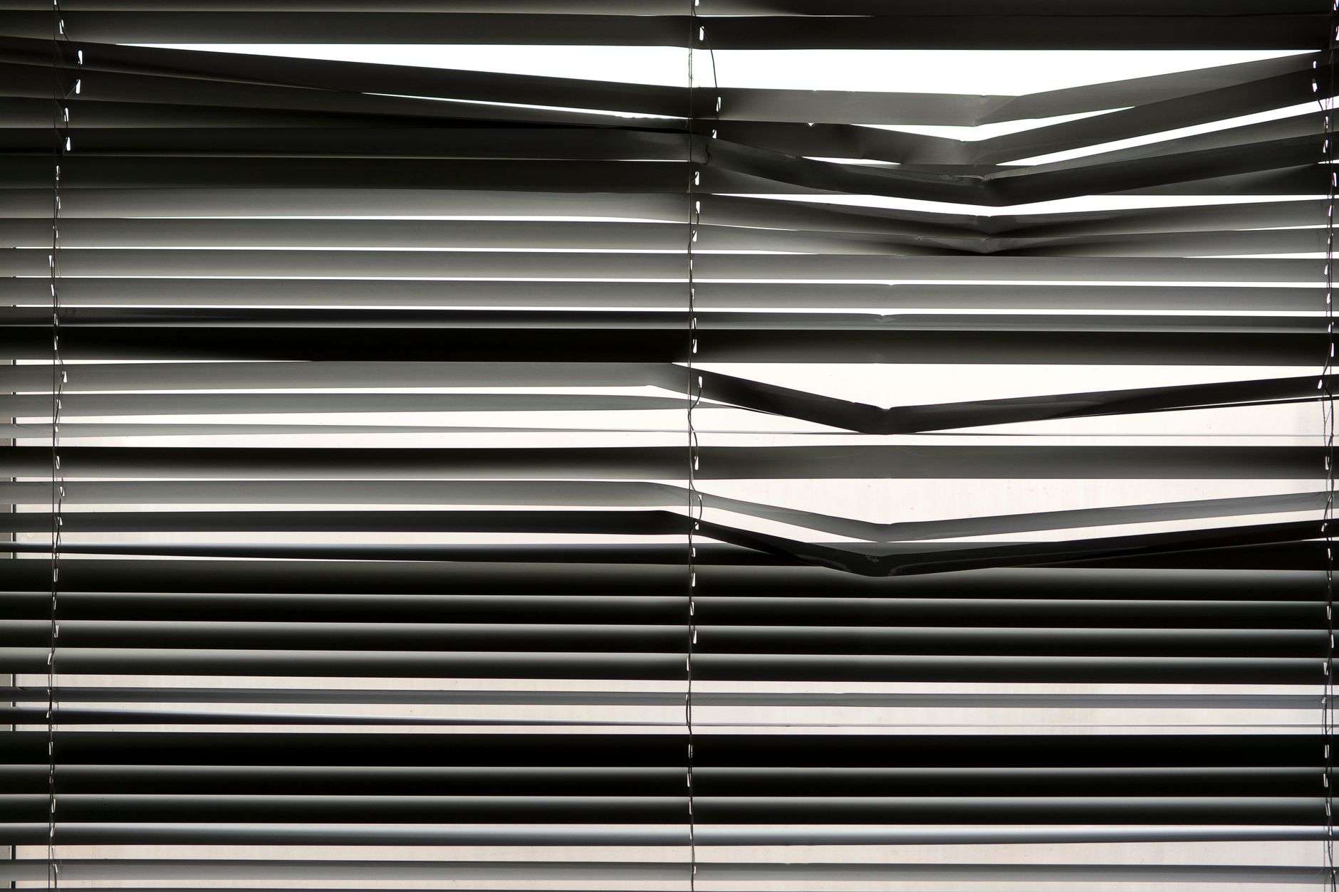 Window blinds filtering sunlight into a bright interior space