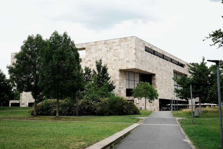 College campus buildings and walkways framed by mature trees