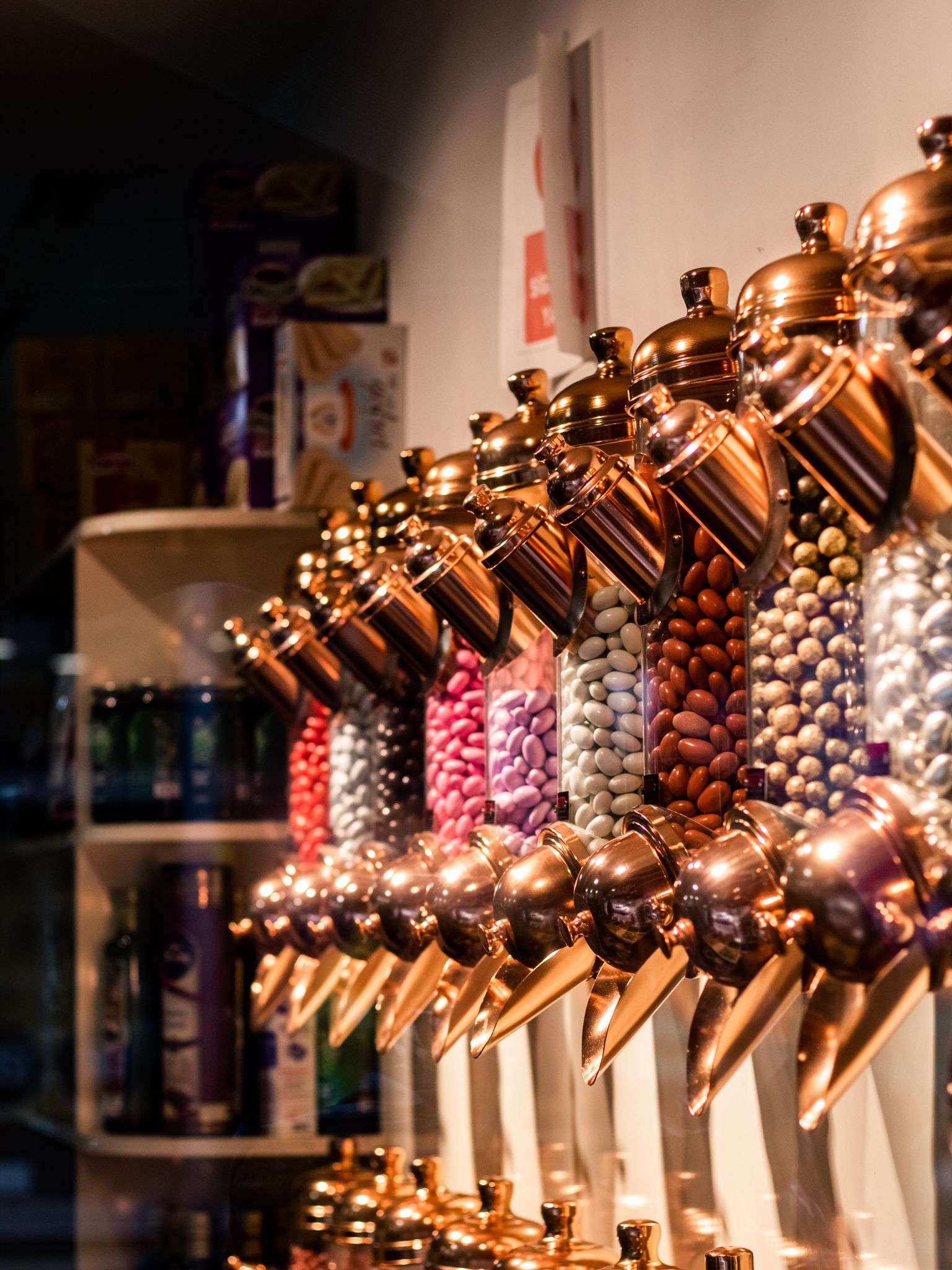 Rows of bulk candy dispensers filled with colorful jelly beans and candies in a specialty sweets shop