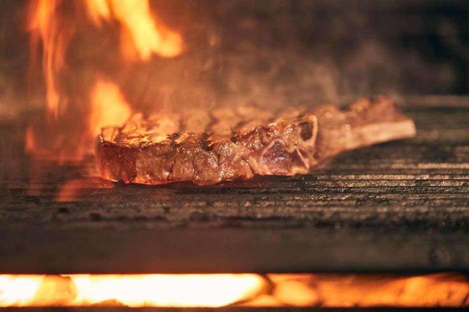 Charred steak served on a plate at an upscale steakhouse table
