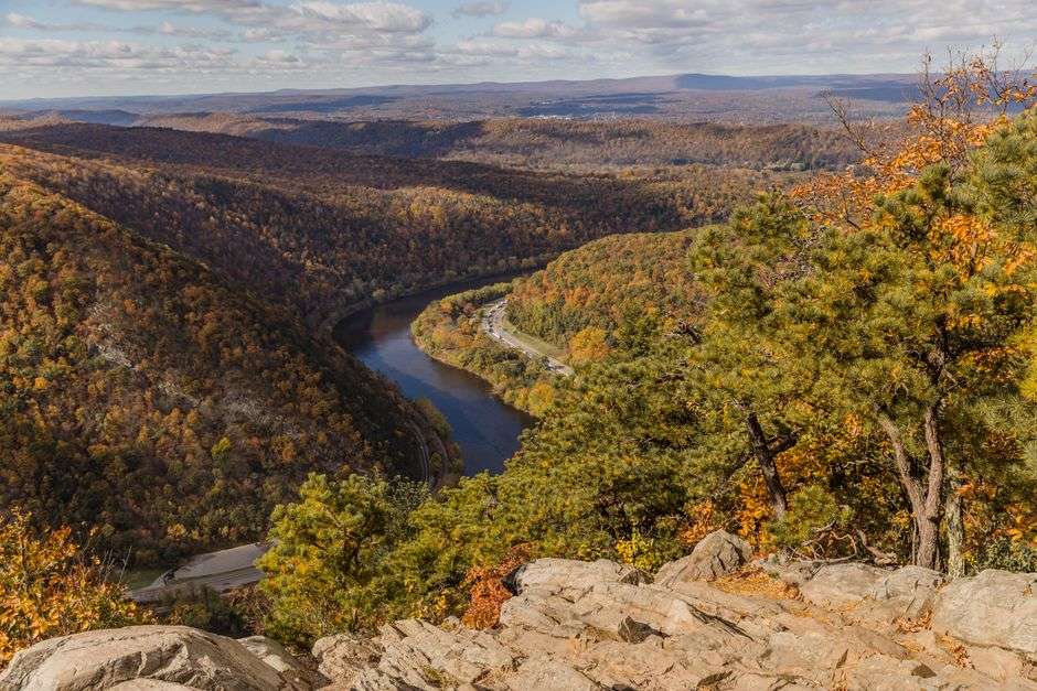 View from a mountain overlook over rolling forested ridges with fall color
