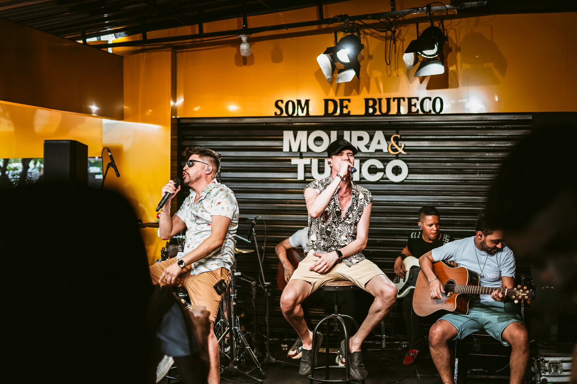 A band with guitars performing on a small stage at a casual live music venue