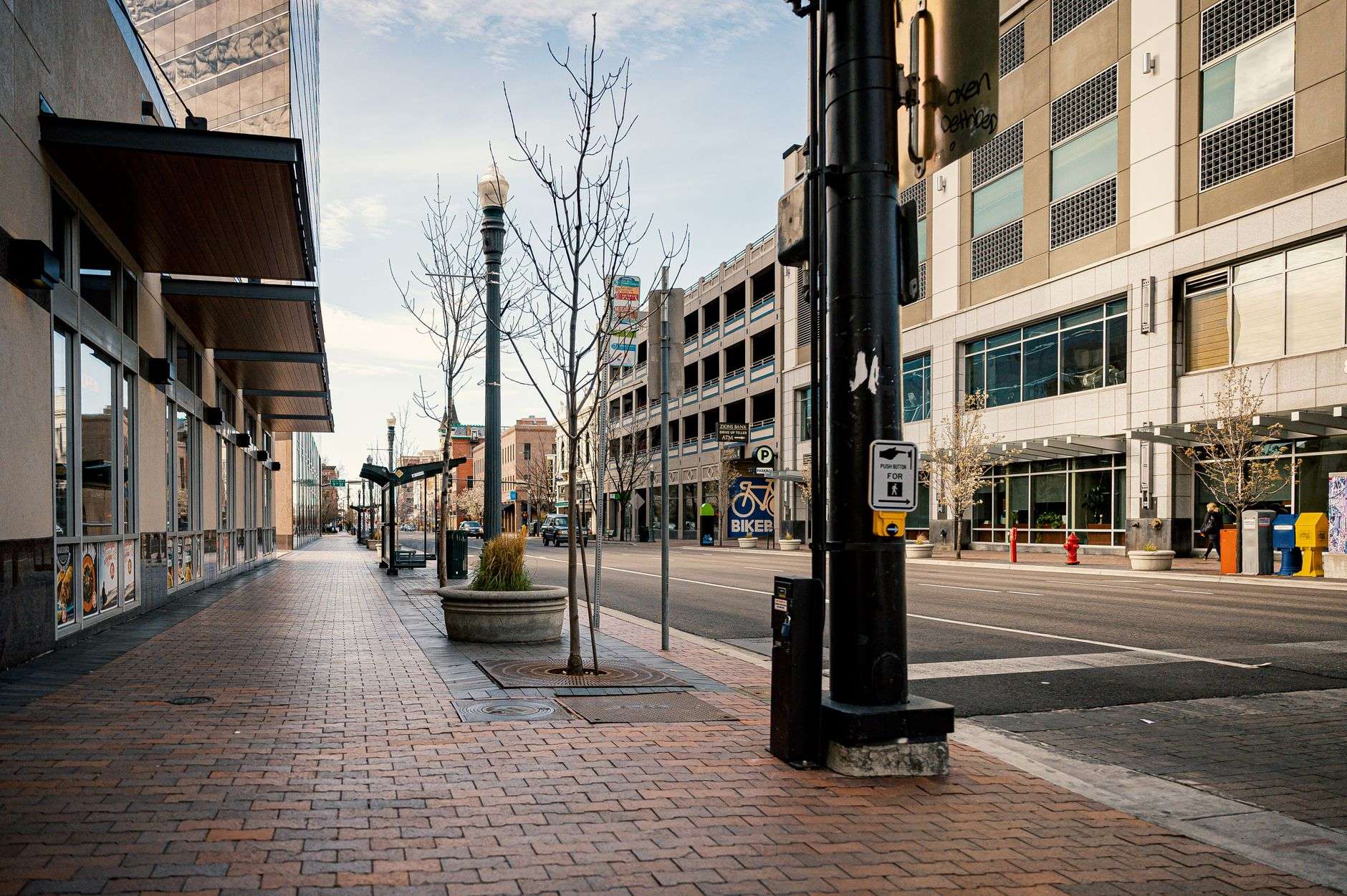 A modest storefront office space along a city avenue with parking out front and open glass doors