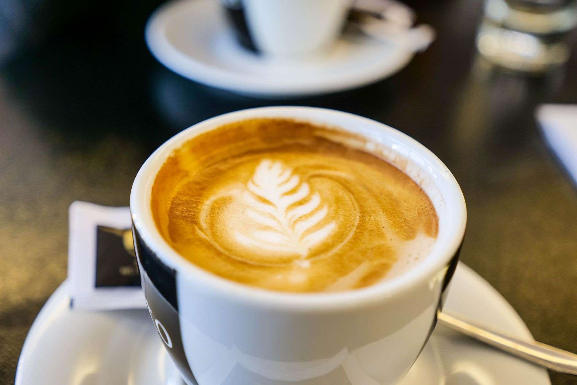 Latte in a ceramic cup on a cafe counter illustrating Coastlands Coffee in Foley