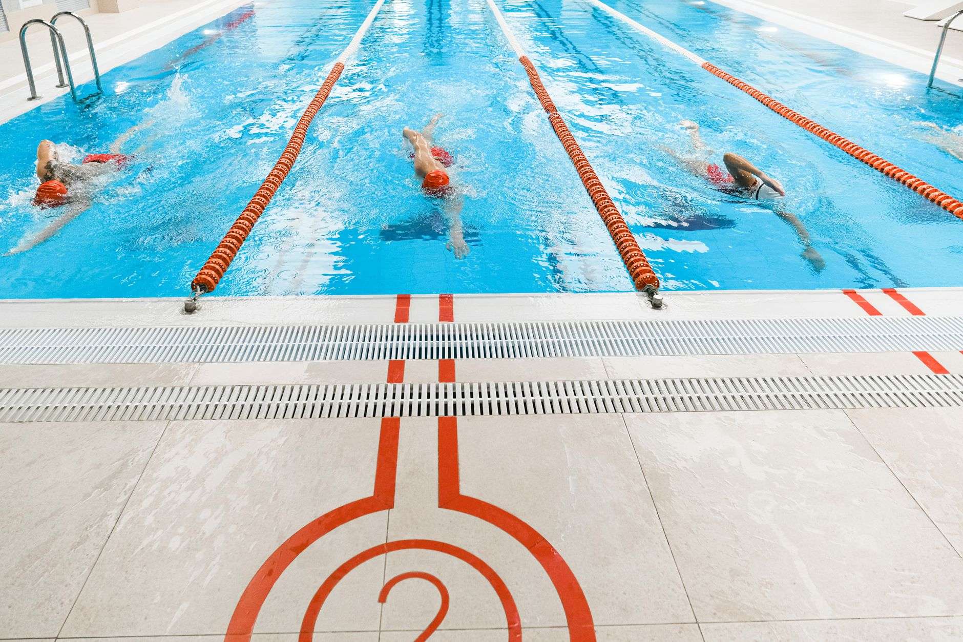Lane lines in an indoor competition swimming pool, illustrating a facility hosting high school swim meets