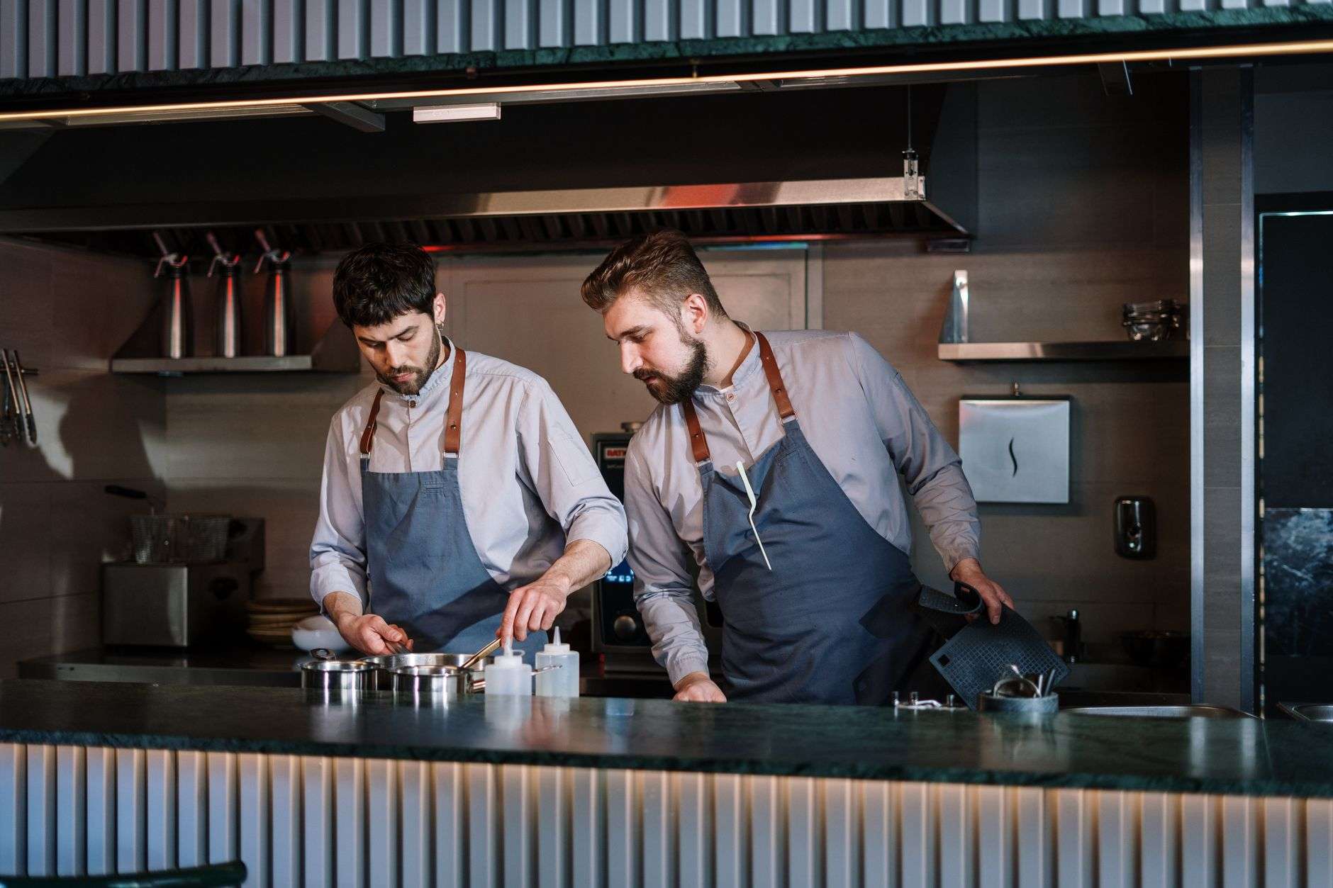 Food being prepared on a stove in a stainless steel commercial kitchen