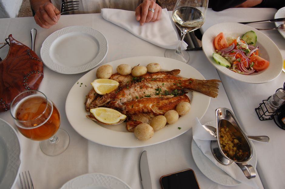 A dinner table set with fresh seafood dishes at a coastal restaurant in Orange Beach