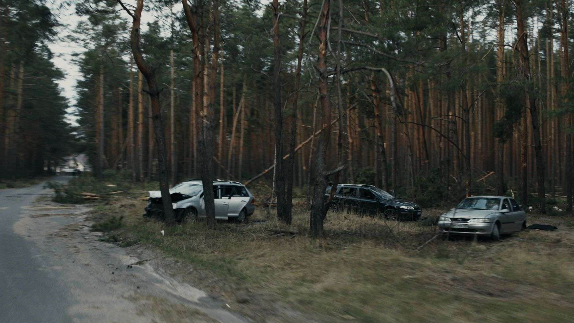 A damaged vehicle at the scene of a roadway collision
