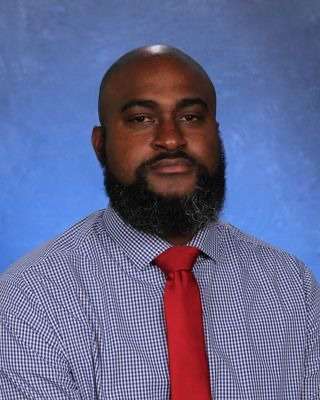 Courtney Bloom in a checked dress shirt and red tie