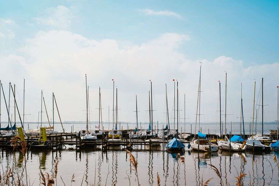 A sailboat sailing on the open water of Pensacola Bay on a clear day