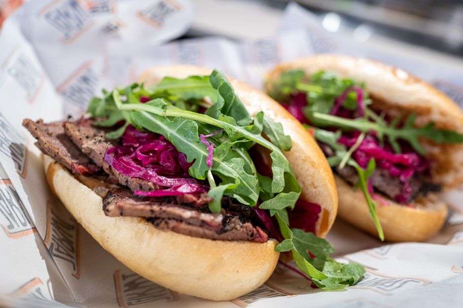 A dressed roast beef po-boy sandwich served on French bread