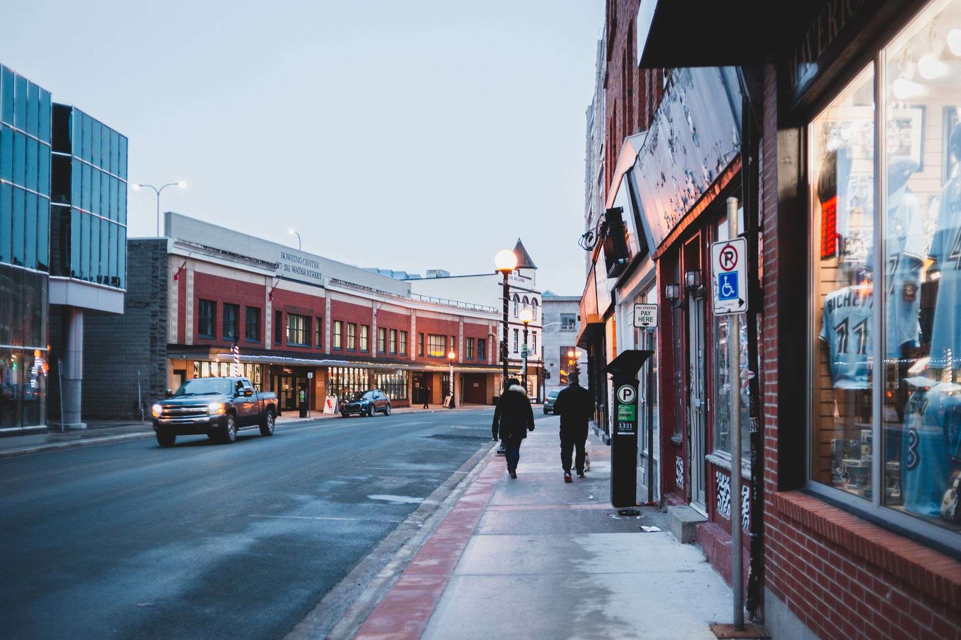 A downtown streetscape with brick walkways and decorative lighting, illustrating a completed complete-street improvement project