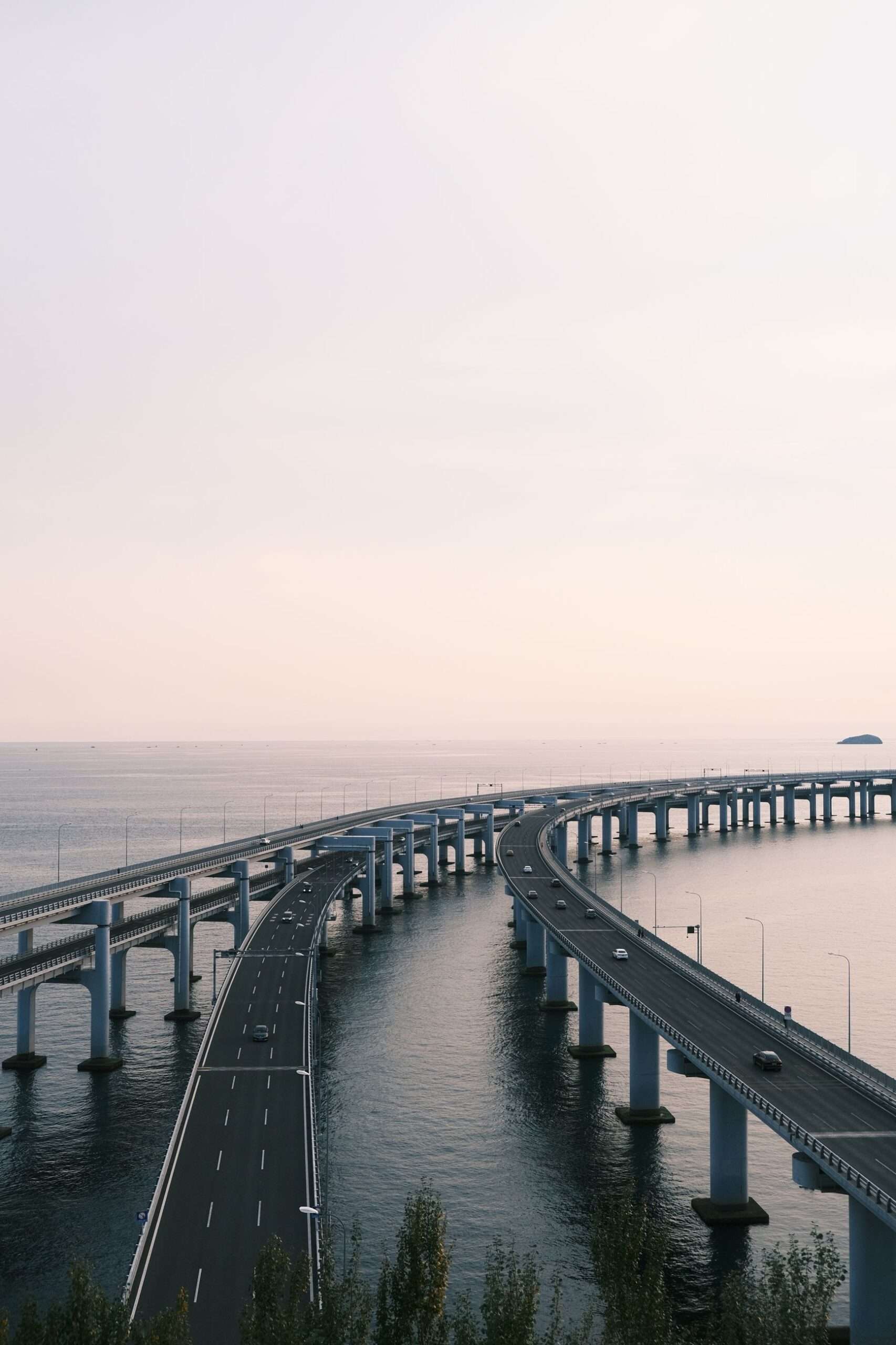 Aerial view of a long elevated highway causeway bridge curving over open water