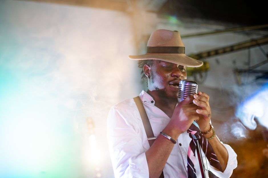 A vocalist singing into a microphone on stage