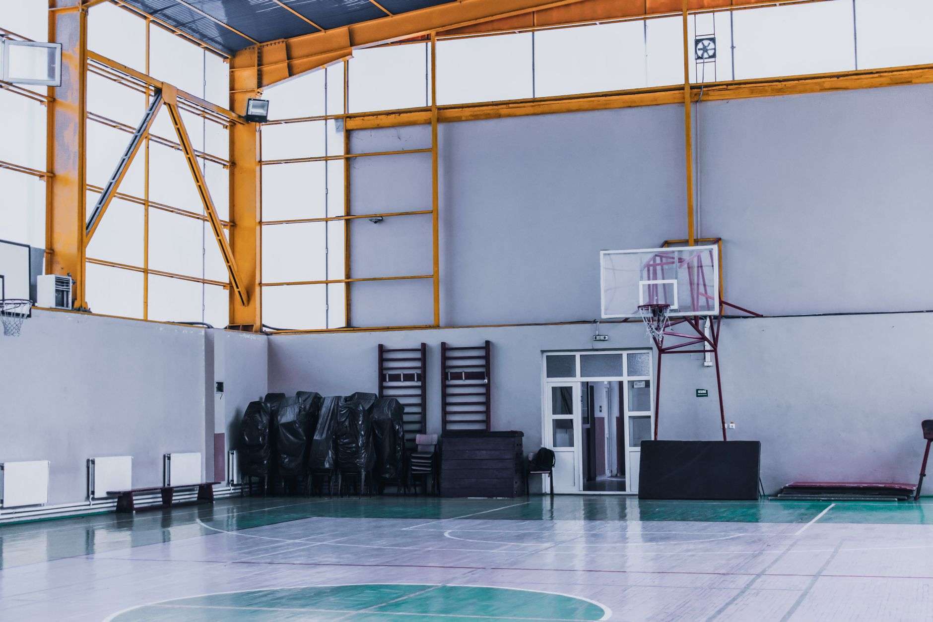 An empty basketball court in a gymnasium, illustrating coverage of a college athlete's death and cardiac screening