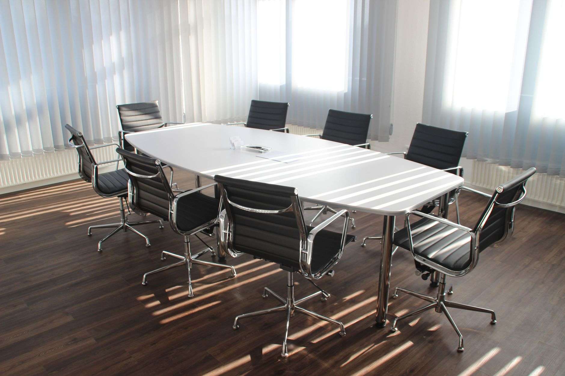 Empty conference room with a table and black office chairs