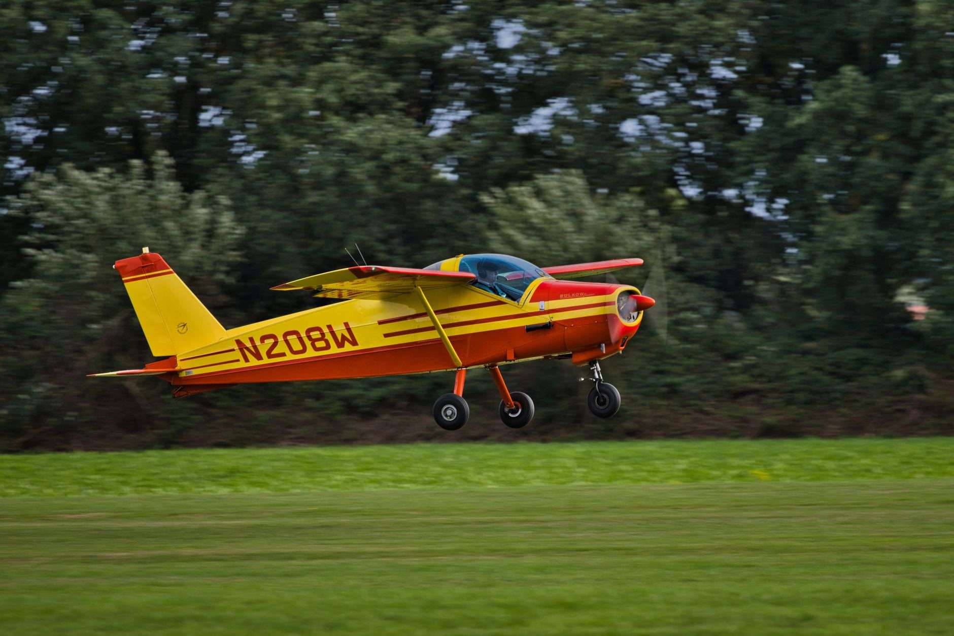 A small single-engine propeller airplane taking off from a runway