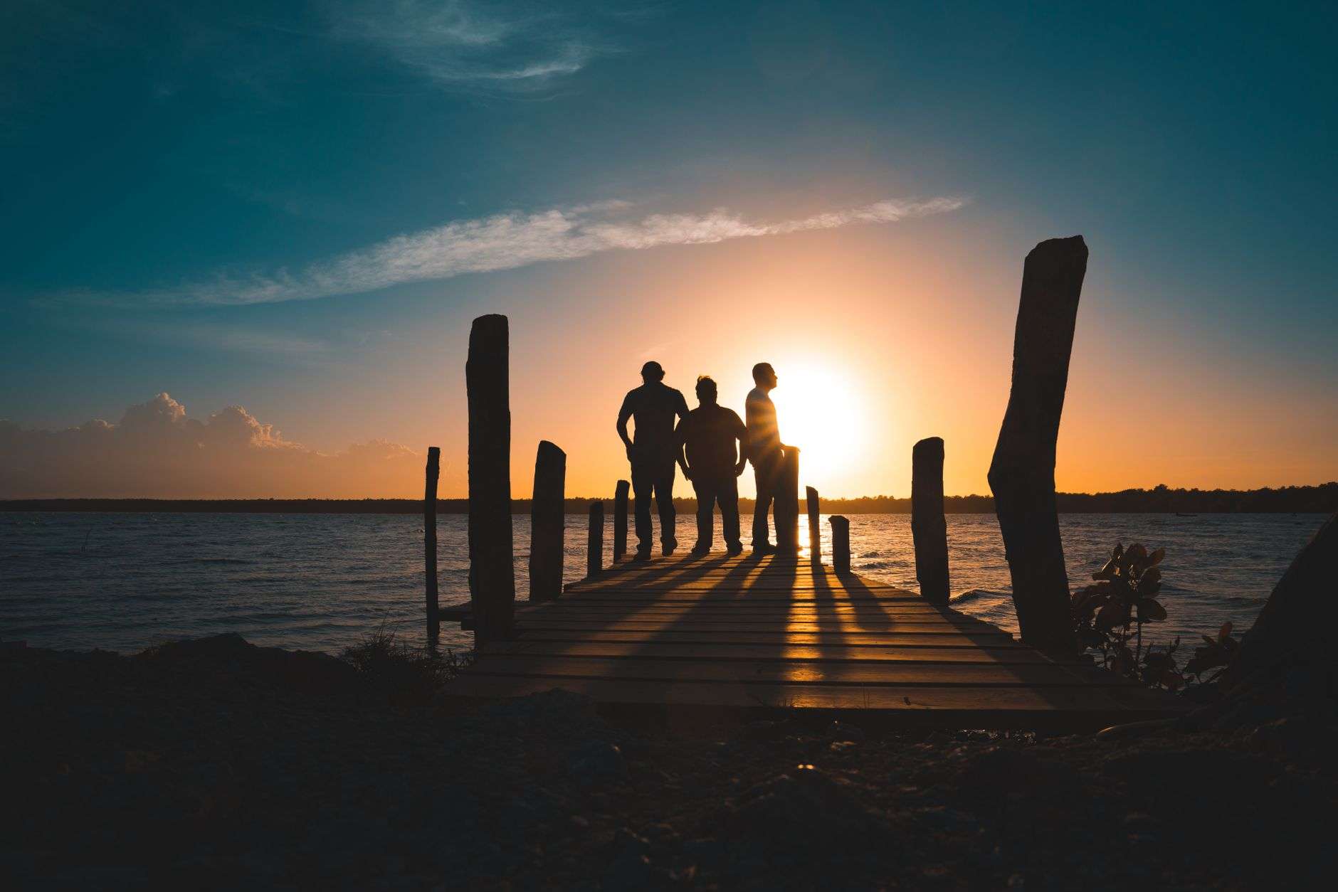 A wooden pier extending into a bay at sunset, illustrating Fairhope's west-facing waterfront on Mobile Bay