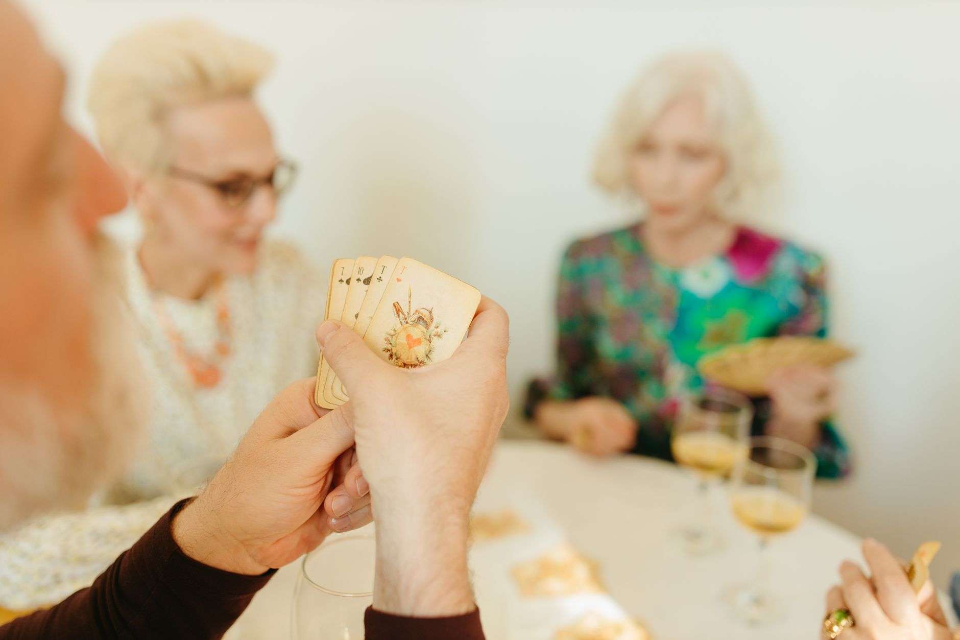 Older adults playing cards together around a table in a community room