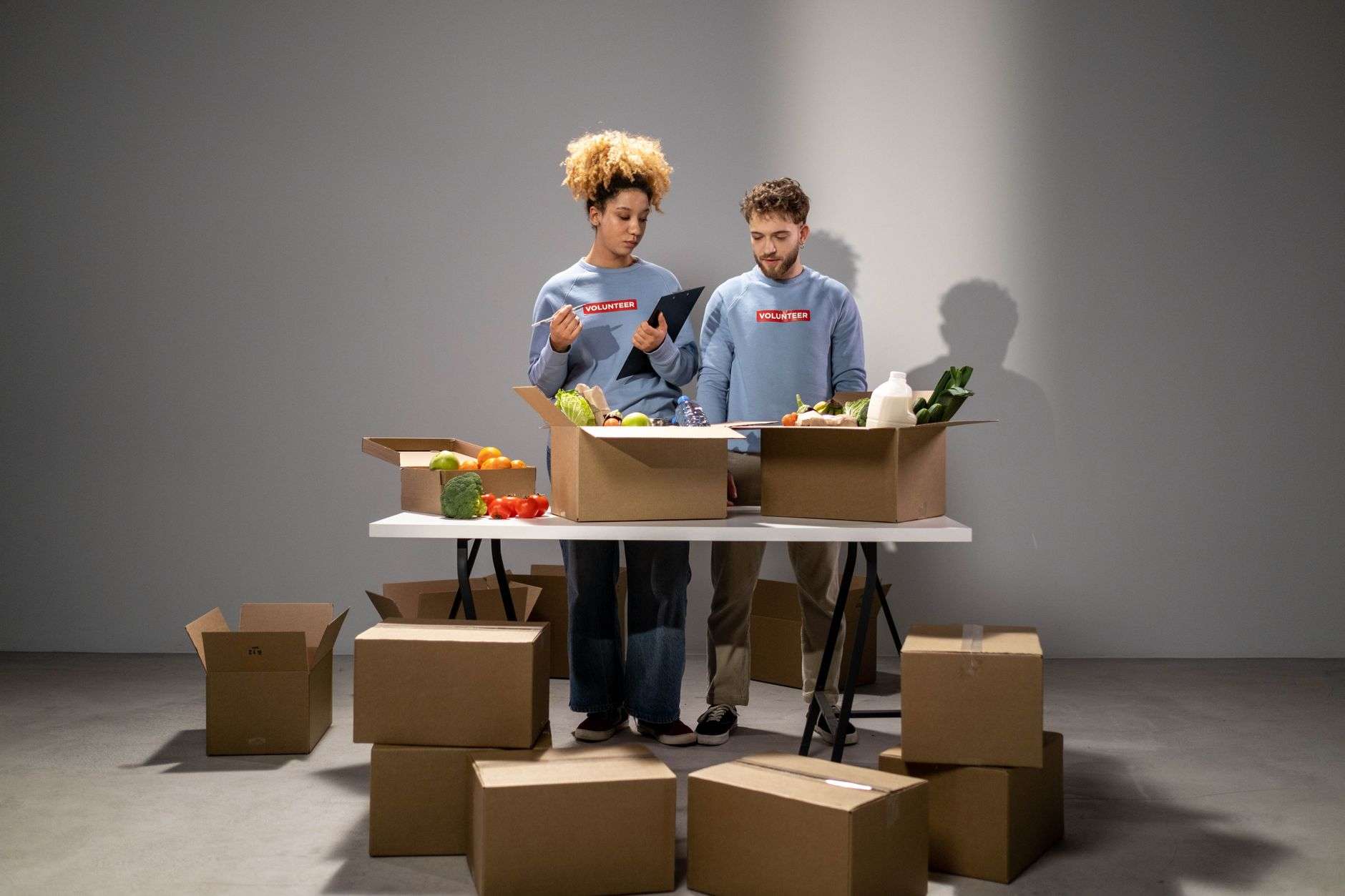 Volunteers sorting boxes of donated food in a warehouse
