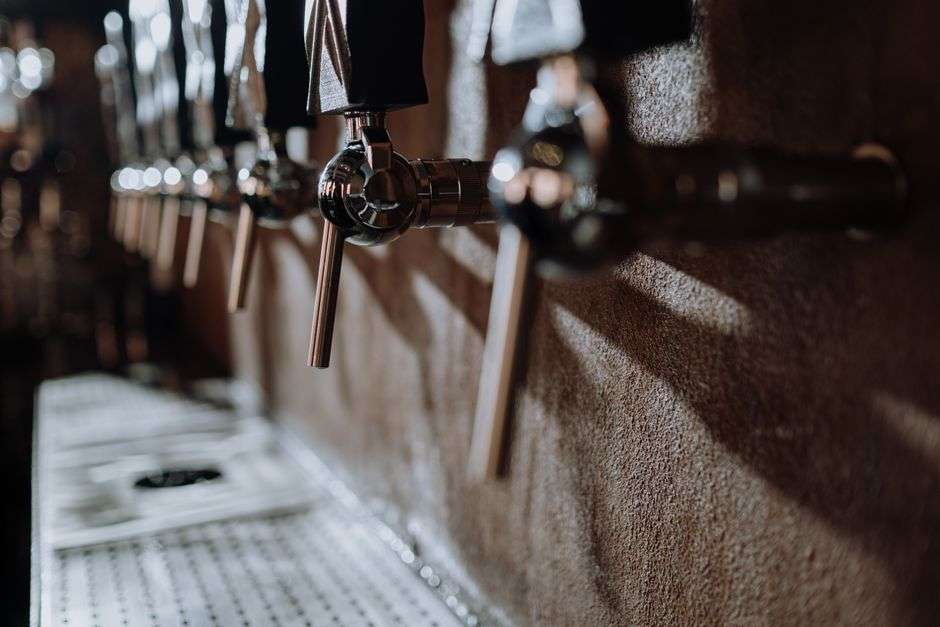 Row of craft beer taps behind the bar at a neighborhood brewpub