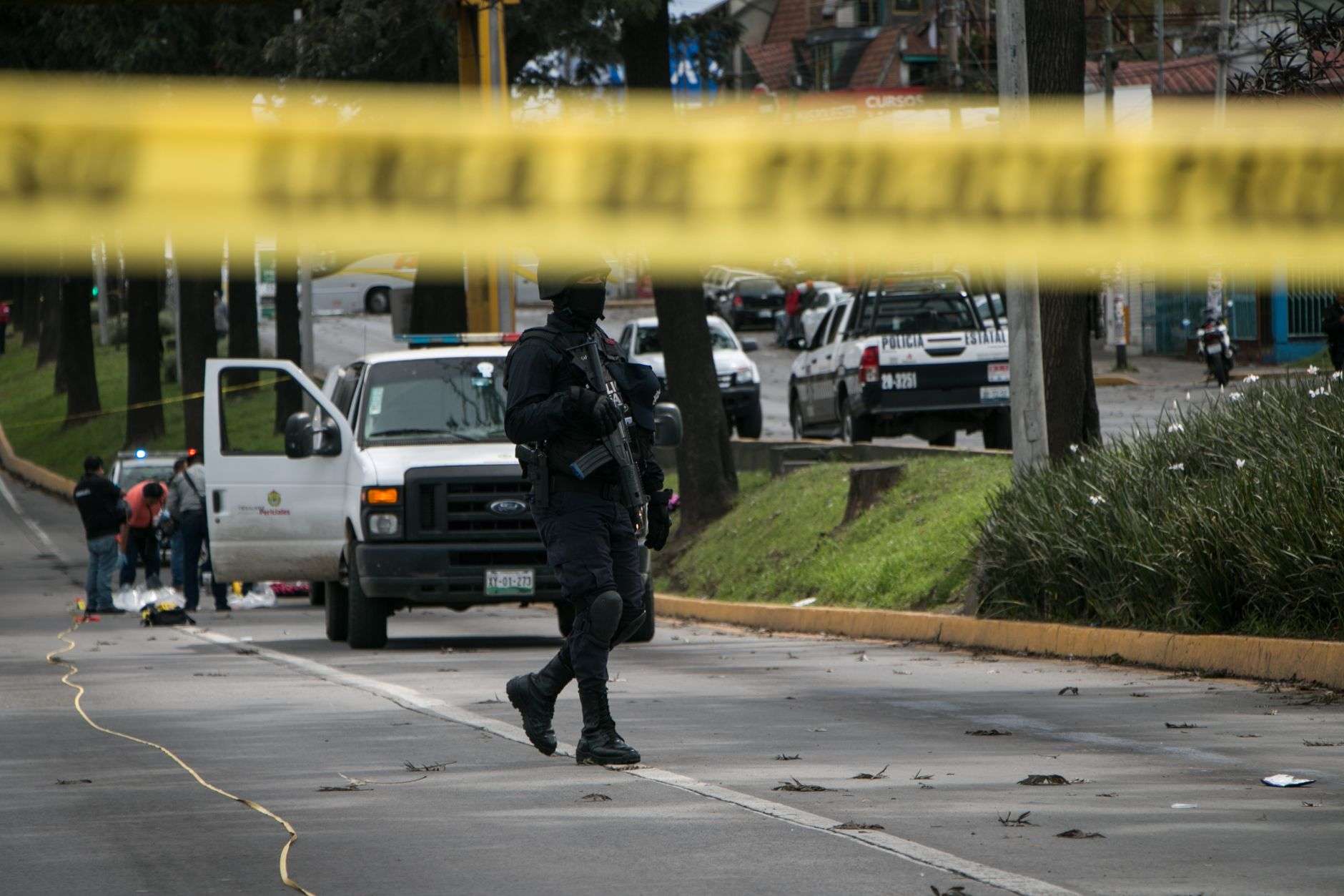 Yellow police tape stretched across a street at a crime scene