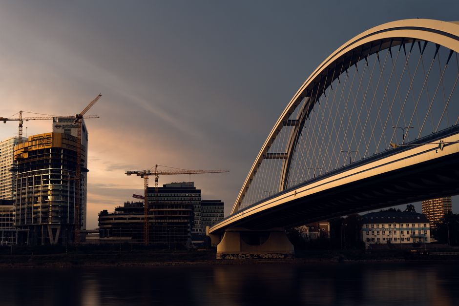 Cranes working on bridge construction over a wide river