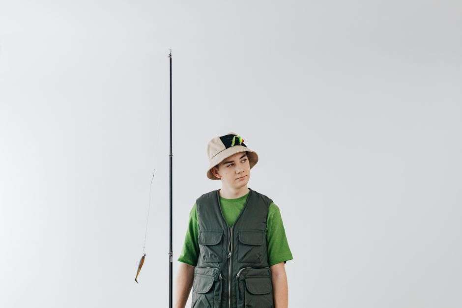 Performance fishing shirt and hat laid out on a boat deck