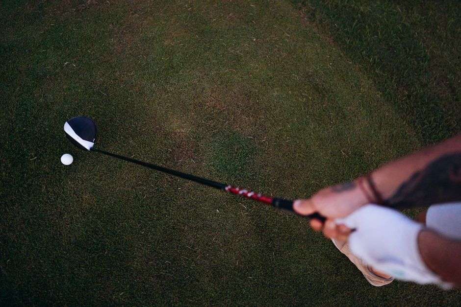 Golfer completing a full swing with a driver on an Alabama golf course
