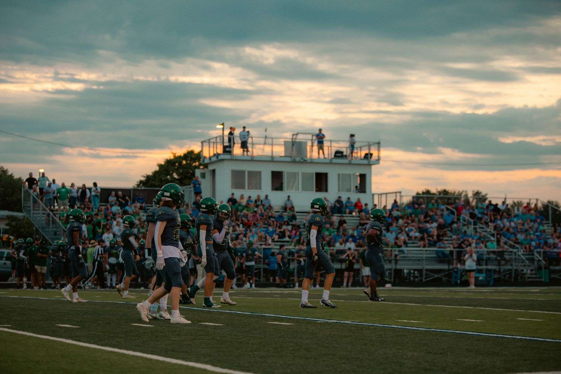 A high school football field with goal posts at dusk