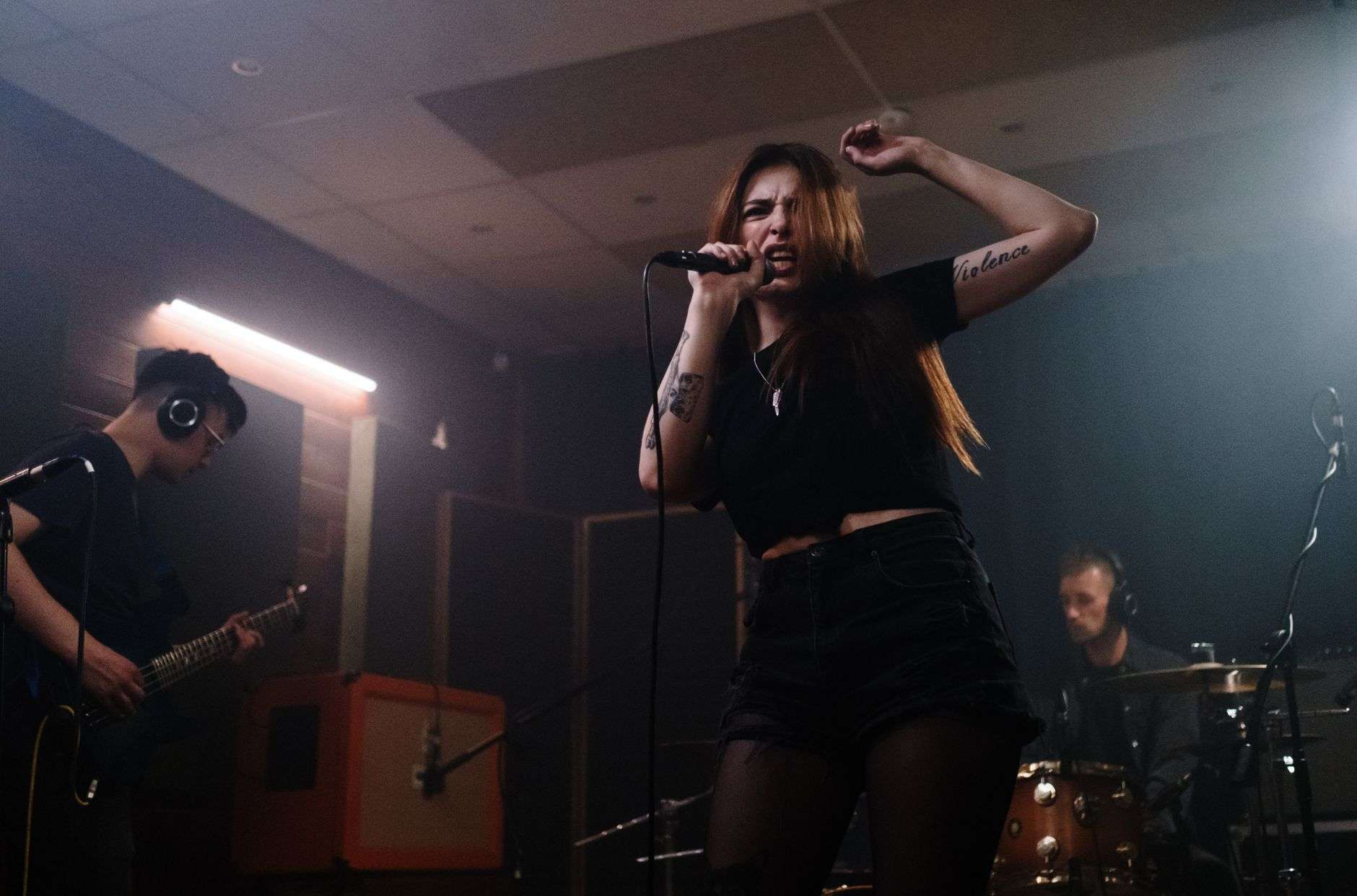 A band performing on stage with microphones and instruments