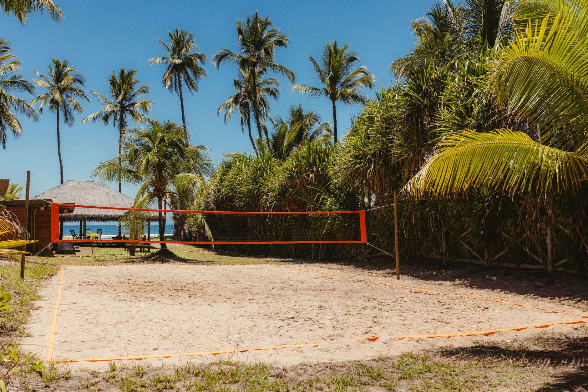 Players competing in a beach volleyball match on a sand court