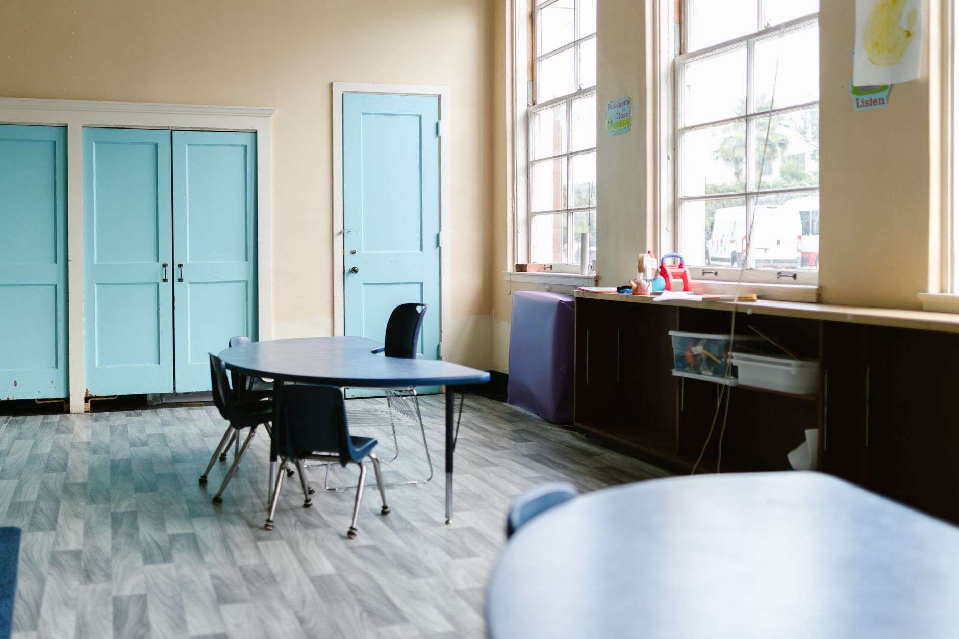 An empty elementary school classroom with desks and chairs